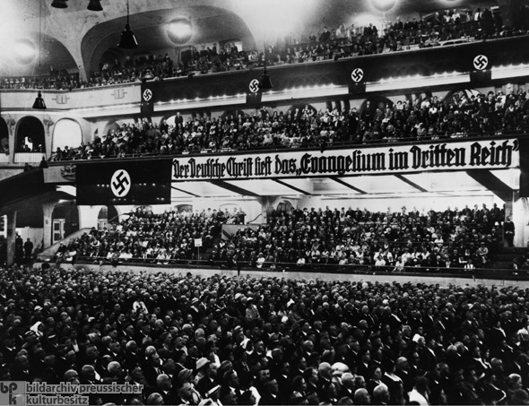 上图：1933年11月13日，德意志基督徒在柏林体育馆举行「运动场集会（Sportpalast rally）」，横幅上写着：「德意志基督徒阅读第三帝国福音」。